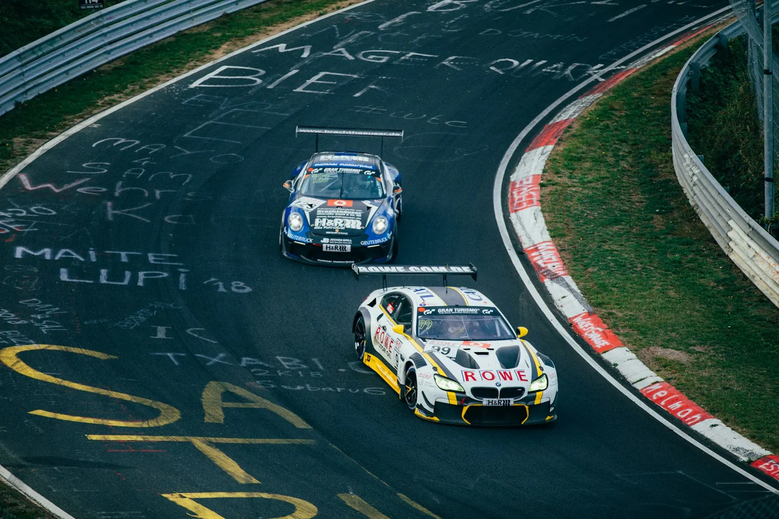 Two GT3 cars through a corner at the Nordschleife