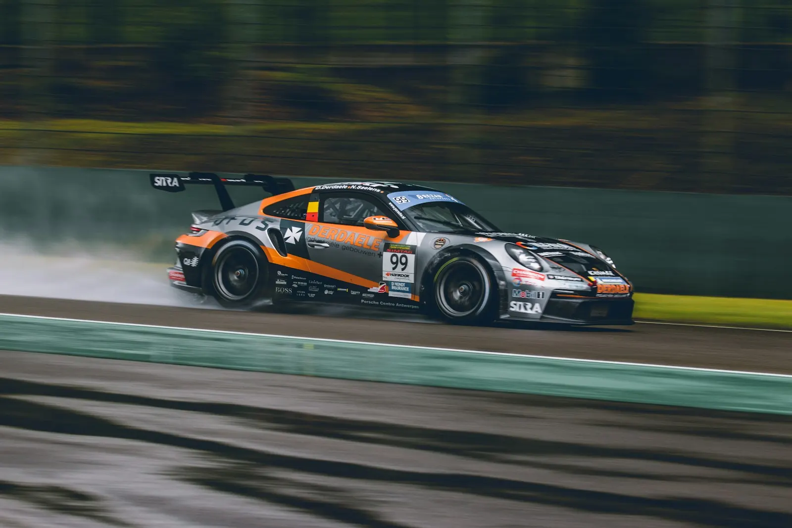 A GT car at speed on a wet track